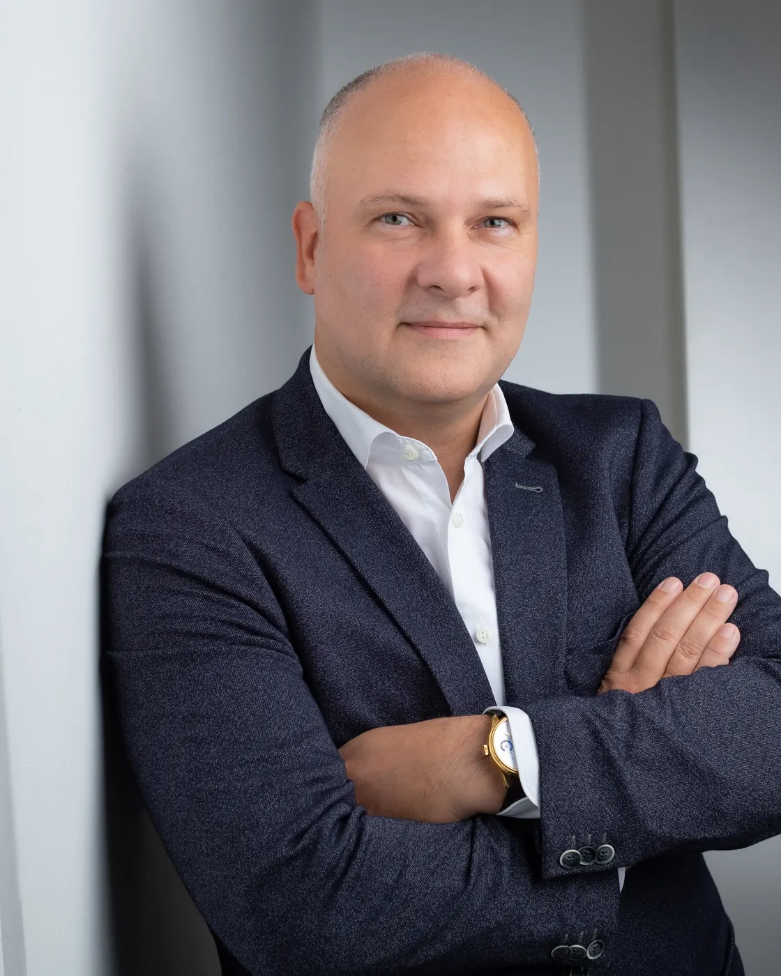 Daniel Horenburg mit verschränkten Armen vor grauem Hintergrund